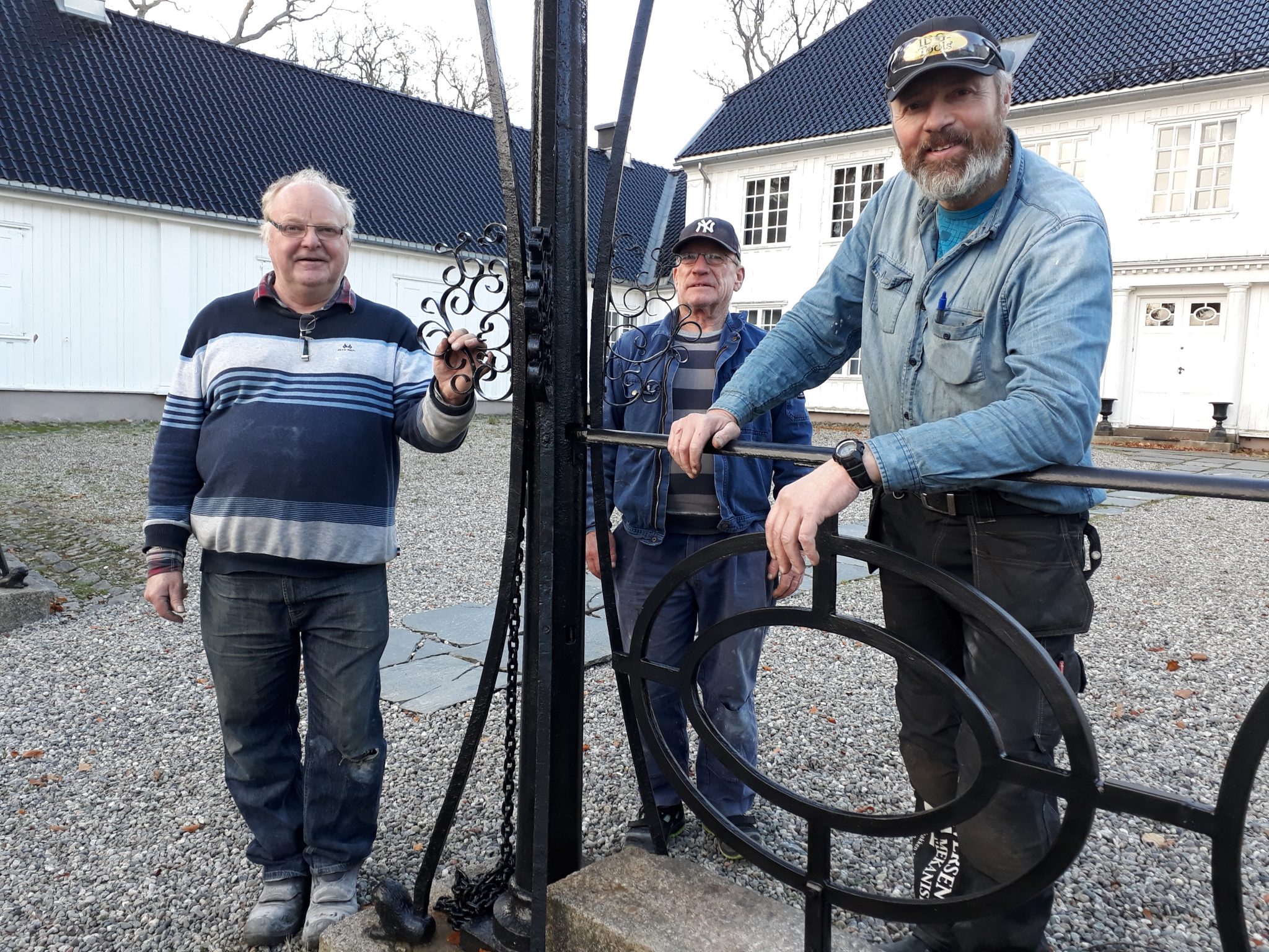 Freddy Iversen, Odd Hansen og Yngve Andersson har montert rekkverket ved Rød herregård. Foto: Bodil Andersson, Østfoldmuseene Halden historiske Samlinger