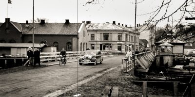 Sort hvit fotografi av en bro med mennesker og en bil