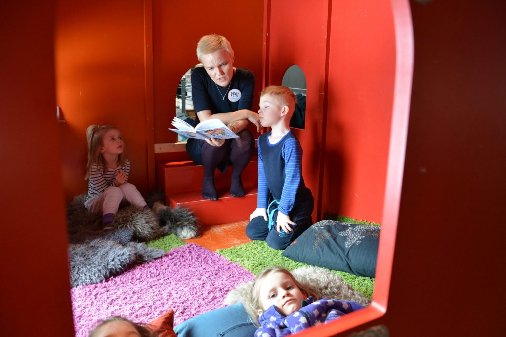 Barna lytter oppmerksomt når museumsvert Mona-Elise leser Karius og Baktus. Foto HBSL