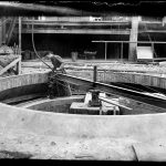 Fra bygging av ovn 3 på Hafslund Karbidfabrikk, 1950-51. Digitaliserte glassplatenegativ som er utvalg fra en serie på nitti fotografier der hele prosessen med utbyggingen av ovn 3 og selve produksjonen ble dokumentert for fabrikken. Fotograf ukjent / Østfold fylkesbilledarkiv.